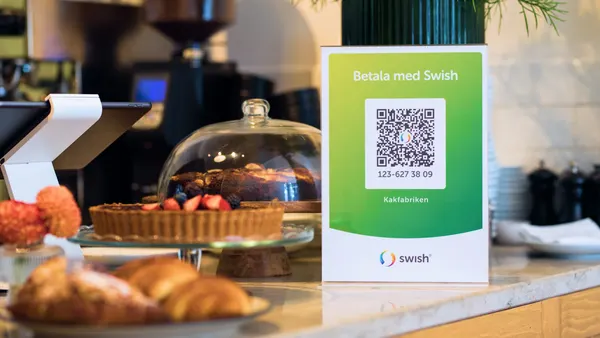 Swish payment signage in a cafe showing green brand materials
